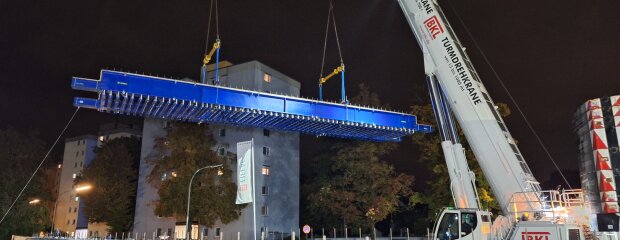 Ein Teil des Traggerüsts wird mit zwei Mobilkränen eingehoben.